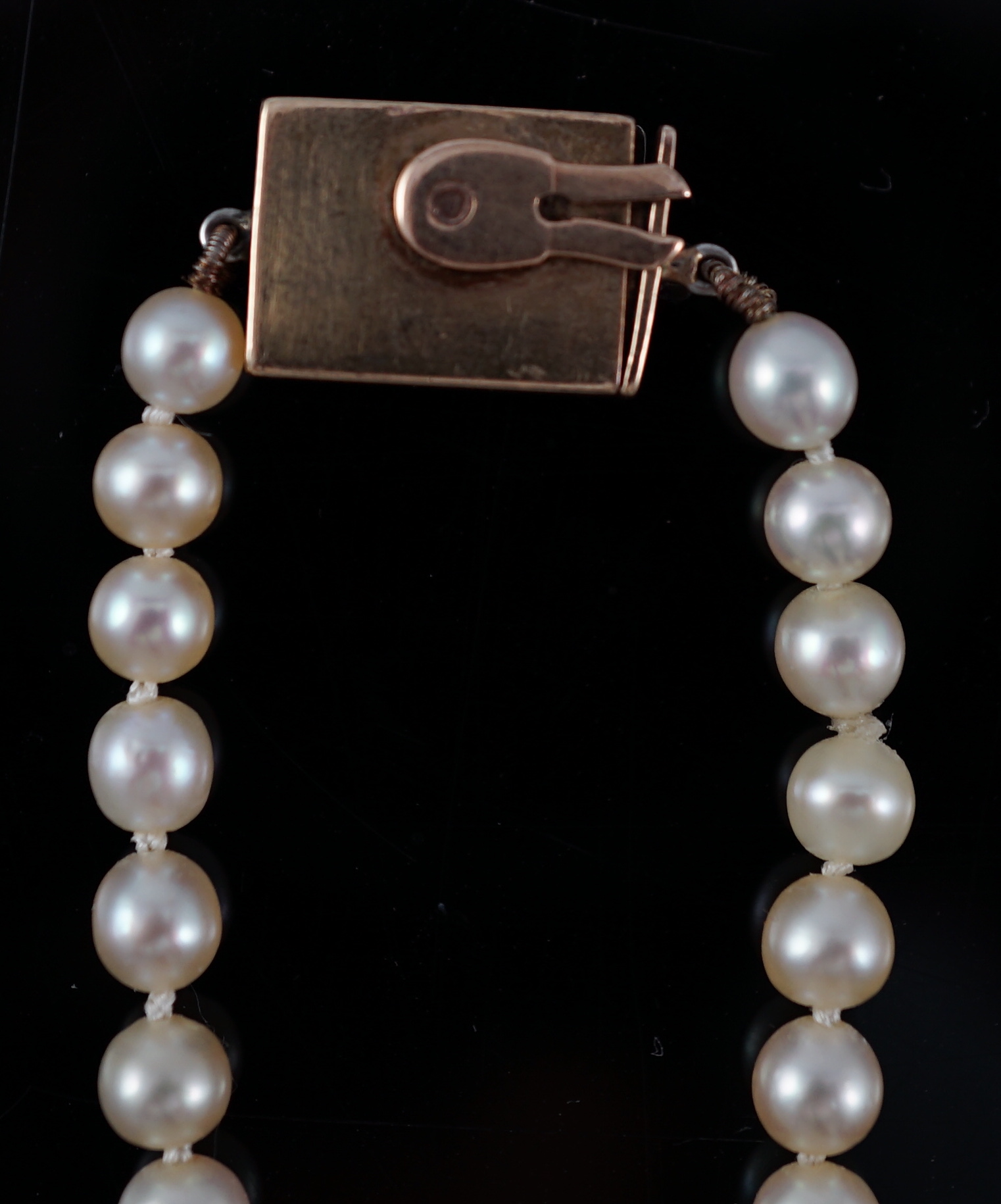 A late Victorian single strand graduated natural saltwater pearl necklace, with six stone old round cut diamond set silver and gold rectangular clasp